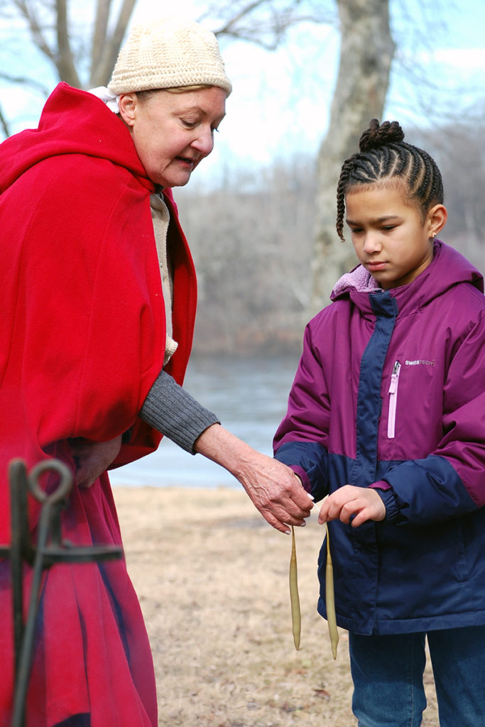 Park volunteer Mary Ryan shows how colonists made candles