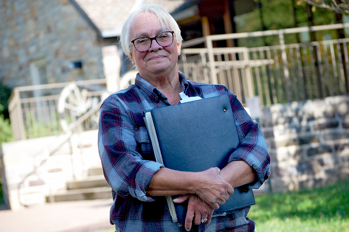 Barbara Felver holds her scrapbook outside the park visitor center.