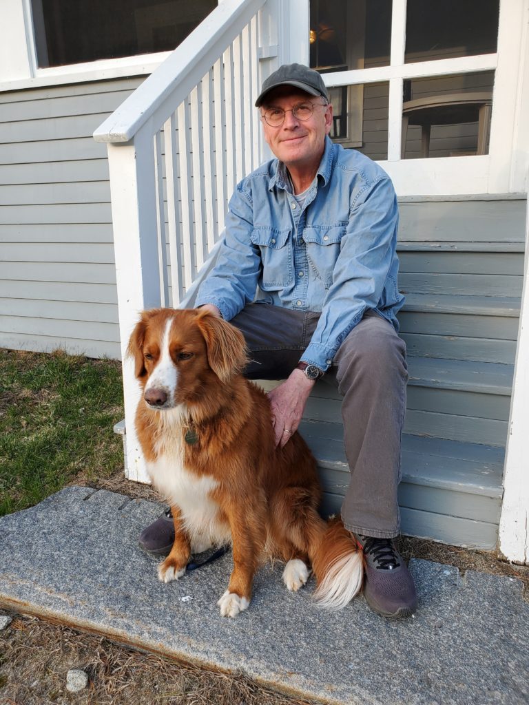 Nathaniel Philbrick and his dog, Dora, sit on steps outside of a home